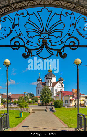 Die schmiedeeisernen Bogen über dem Eingang zur Kegelbahn und die schöne Kirche im Hintergrund. Für ihr Design Stockfoto
