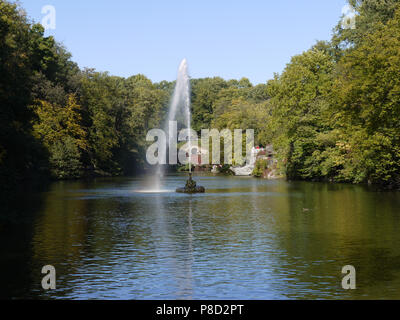 Eine hohe Jet der Brunnen, aus dem Mund einer Schlange ist entlang der Oberfläche eines großen Sees im Park gesprüht. Für ihr Design Stockfoto