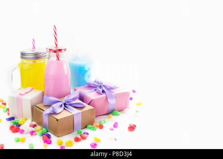 Dekorative Komposition festliche exotischen Cocktail auf weißem Hintergrund mit Konfetti Geschenk Satinband. Natürliche Drink in ein Glas mug Stockfoto