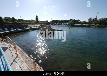 Eine kleine Pier mit großen Steinen am Meer mit kristallklarem Wasser. Für ihr Design Stockfoto