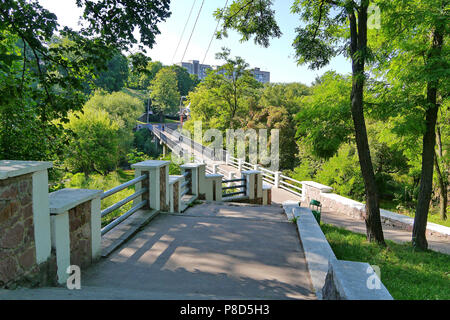 Eine breite Treppe in einem Park mit Metallschienen, die zu einer hohen Gebäuden in der Ferne. Für ihr Design Stockfoto