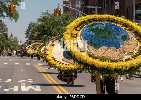 Die Teilnehmer an der 9. jährlichen Blumenkorso (Desfile de las Flores) in der Jackson Höhen Stadtteil Queens in New York am Sonntag, 8. Juli 2018. Die Parade, komplett mit silleteros, blumenverkäufer, die Medaillons von Blumen auf dem Rücken wie die silleteros, die Sie auf dem Rücken tragen die Berge hinunter in Kolumbien rund um die Stadt Medellin am Markt zu verkaufen. Stockfoto
