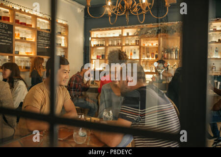 Lächelnden jungen Freunden in einer Bar zusammen zu sitzen Stockfoto