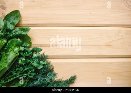 Spinat, grüner Salat und Dill auf einer hölzernen Oberfläche. Mischung der Grüns. Gesunde Lebensmittel. In der Nähe Platz für Text. Stockfoto