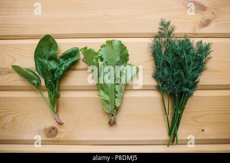 Spinat, grüner Salat und Dill auf einer hölzernen Oberfläche. Mischung der Grüns. Gesunde Lebensmittel. Stockfoto