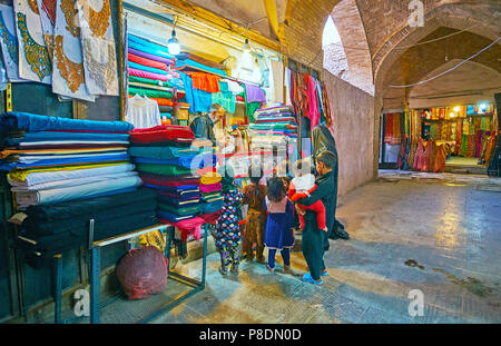 KERMAN, IRAN - 15. Oktober 2017: Die Familie mit vielen Kindern aus Stoffen bei Textile Speichern der alten Vakil Basar, die am 15. Oktober in Kerman. Stockfoto