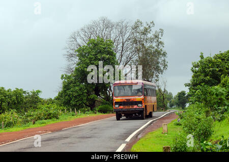 Classic, gewöhnlichen roten Bus Der MSRTC (Maharashtra State Road Transport Corporation) auf einer schmalen Straße durch eine landschaftlich reizvolle Strecke. Stockfoto