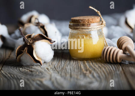 Baumwolle Honig in einem Glas Flasche auf einer hölzernen Oberfläche. Nahaufnahme Stockfoto