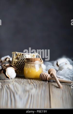 Baumwolle Honig in einem Glas Flasche auf einer hölzernen Oberfläche. Nahaufnahme Stockfoto