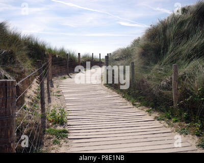 Fußgängerbrücke führt zu einem Strand, mit Zaun auf dem Weg zu einem besseren Leben mit mehr Freizeit Stockfoto