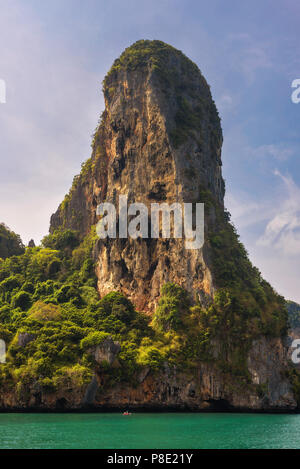 Kleines Boot unter riesigen Felsen von Phi Phi Inseln Stockfoto