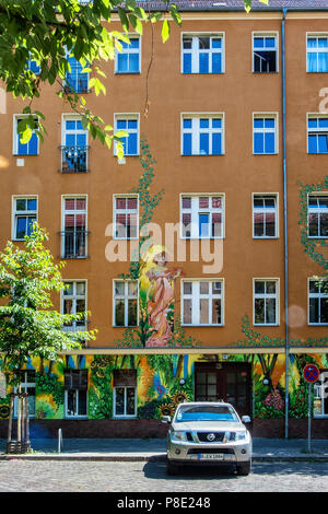 Berlin, Prenzlauerberg, Lychnener Straße. Farbenfrohe Gebäude mit Blumen bemalte Fassade enthält Wohnungen und Büros. Blick auf die Straße von mehrfamilienhaus Stockfoto