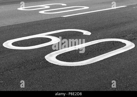 60 km pro Stunde. Tempolimit Fahrbahnmarkierung auf dunkelgrau Asphalt Stockfoto