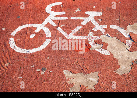 Rad weg. Grunge weiße Straße Markierung über rot lackiert konkrete Straße Stockfoto