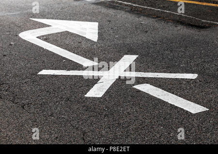 Rechts ist verboten. Weißer Pfeil, Straßen Markierung über schwarze Landstraße Asphalt gekreuzt. Nahaufnahme mit selektiven Fokus Stockfoto