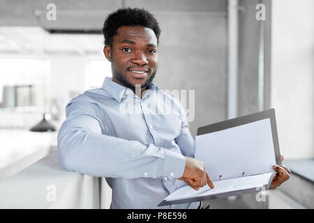 Afrikanische amerikanische Geschäftsmann mit Ordner im Büro Stockfoto
