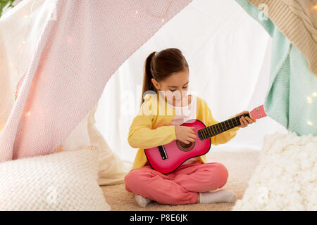 Mädchen spielen Spielzeug Gitarre im Kinder Zelt zu Hause Stockfoto