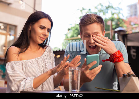 Der moderne Mensch vor Lachen, laut, während Sie alte Fotos Stockfoto