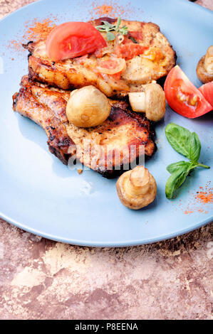 Gegrilltes Fleisch, Steak, Tomaten, Kräutern und Gewürzen auf der Platte. BBQ-Fleisch Stockfoto