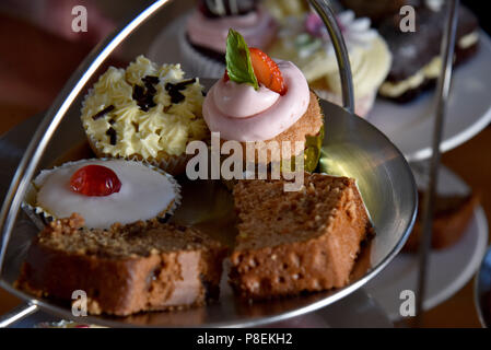 Bild zeigt einen Kuchen stand mit Torten, einschließlich einer Tasse Kuchen, eine Scone, Datum und Walnuss Kaffee und einem Stück Kuchen Stockfoto