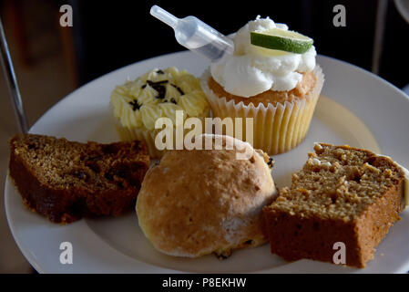 Bild zeigt einen Kuchen stand mit Torten, einschließlich einer Tasse Kuchen, eine Scone, Datum und Walnuss Kaffee und einem Stück Kuchen Stockfoto