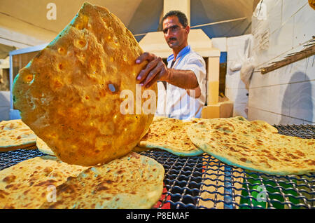 KERMAN, IRAN - 15. Oktober 2017: Die Bäcker bei der Arbeit - die kleine Bäckerei bietet warme, frisch und lecker Fladenbrot, nur aus dem Ofen, am 15. Oktober in Ke Stockfoto