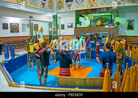 KERMAN, IRAN - 15. Oktober 2017: Die Athleten Durchführen der traditionellen persischen Training mit schweren Holzmöbeln indischen Vereine in Zurkhaneh Sport Club, Oktober Stockfoto