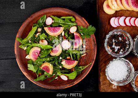 Zutat und Salat braunen-mix Blatt auf Holz Schneidebrett. Radieschen, Salat, Mangold, Petersilie, Dill, Rucola, Mandeln, Salz, lecker, Balsamico, Stockfoto