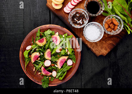 Zutat und Salat braunen-mix Blatt auf Holz Schneidebrett. Radieschen, Salat, Mangold, Petersilie, Dill, Rucola, Mandeln, Salz, lecker, Balsamico, Stockfoto