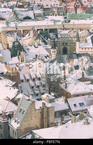 Häuser in weißen Schnee und ein Dach mit Schornsteinen der alten Stadt von Riga an einem sonnigen Tag Stockfoto