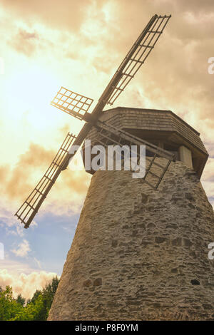 Alte Mühle mit vier Flügeln auf dem Hintergrund der selenis Bäume und Dramatischer Himmel Stockfoto