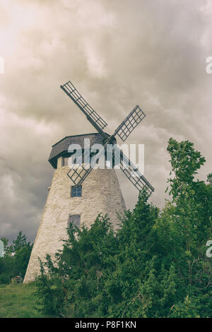 Alte Mühle mit vier Flügeln auf dem Hintergrund der selenis Bäume und Dramatischer Himmel Stockfoto