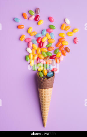 Sweet Jelly Beans und Eis auf farbigen Hintergrund. Stockfoto