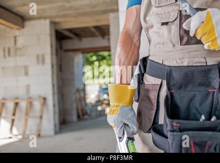 Der Mann macht. Bau Job Konzept. Kaukasische Auftragnehmer Arbeiter mit Tools closeup Foto. Stockfoto