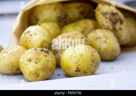 Gebratene Kartoffeln mit Kräutern in Papiertüte Stockfoto