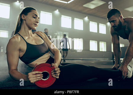 Passen junge Frau heben Barbells in einem Fitnesscenter zu trainieren Stockfoto