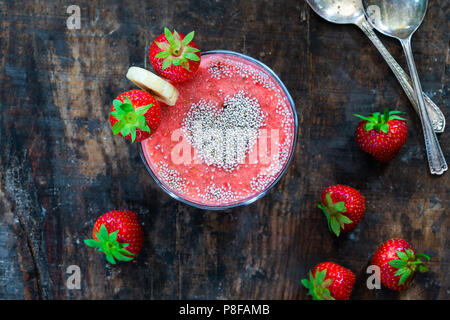 Erdbeeren und Bananen Smoothie garniert mit Chia Samen - Ansicht von oben. Gesundes Frühstück Idee. Stockfoto