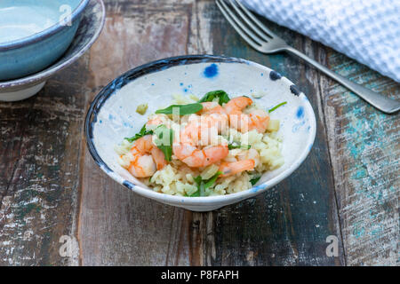 Garnelen, Fenchel und Rucola Risotto auf einem Tisch in der gargen. Im Freien speisen. Stockfoto