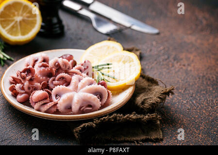 Tintenfische in der Platte mit Zitrone und Rosmarin Stockfoto