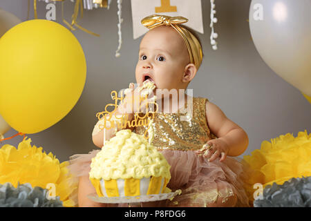 Neugierig Baby Boy stossen Finger in seinem ersten Geburtstag Kuchen Stockfoto