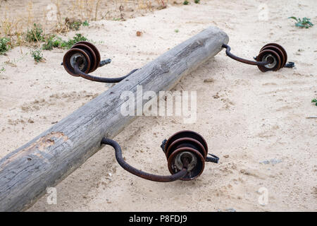 Einem alten hölzernen Strommast auf dem Boden liegen. Beschädigung der elektrischen Netz. Jahreszeit des Sommers. Stockfoto