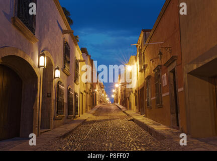 Eine schöne, ruhige Straße mit Kopfsteinpflaster in der Dämmerung in der berühmten Stadt San Miguel de Allende, Mexiko. Stockfoto