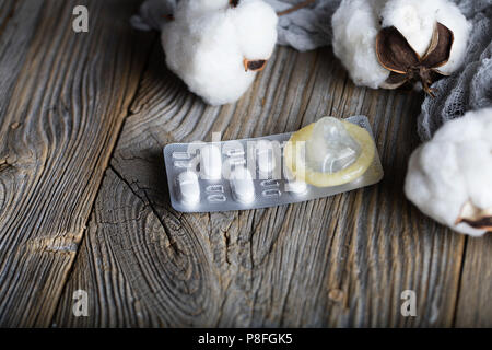 Pille und Kondom auf eine Holz- Oberfläche. Nahaufnahme Stockfoto