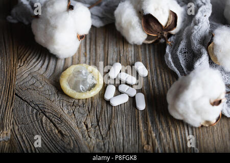 Pille und Kondom auf eine Holz- Oberfläche. Nahaufnahme Stockfoto