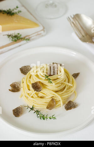 Pasta mit cremiger Käse Sauce und Trüffel auf eine leichte Platte, serviert mit Käse und Wein. Selektive konzentrieren. Stockfoto