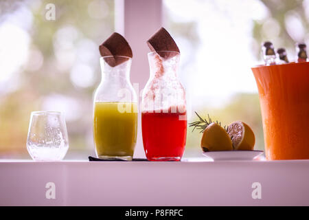 Zwei Flaschen mit Limonade (Mint und Waldfrüchten), eine leere schmutzigen Glas und einer in Scheiben geschnittenen Zitrone mit Rosmarin auf eine Bar Stockfoto