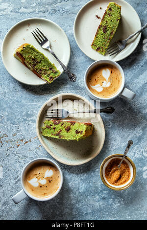 Scheiben von Schokolade mint Kuchen auf der Platte und zwei Tassen Kaffee auf den Tisch Stockfoto