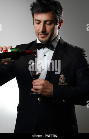 Junger Kellner serviert Wein, Weinprobe Stockfoto