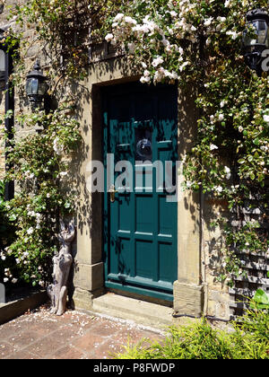 Ein hübsches Häuschen Tür und Tor der Blau/grüne Tür ist von wilden Blumen in super Gärten in einem privaten Haus in South Yorkshire umgeben Stockfoto