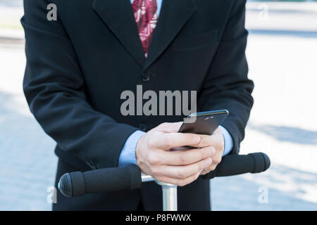 Geschäftsmann mit Mobiltelefon am Lenkrad Stockfoto
